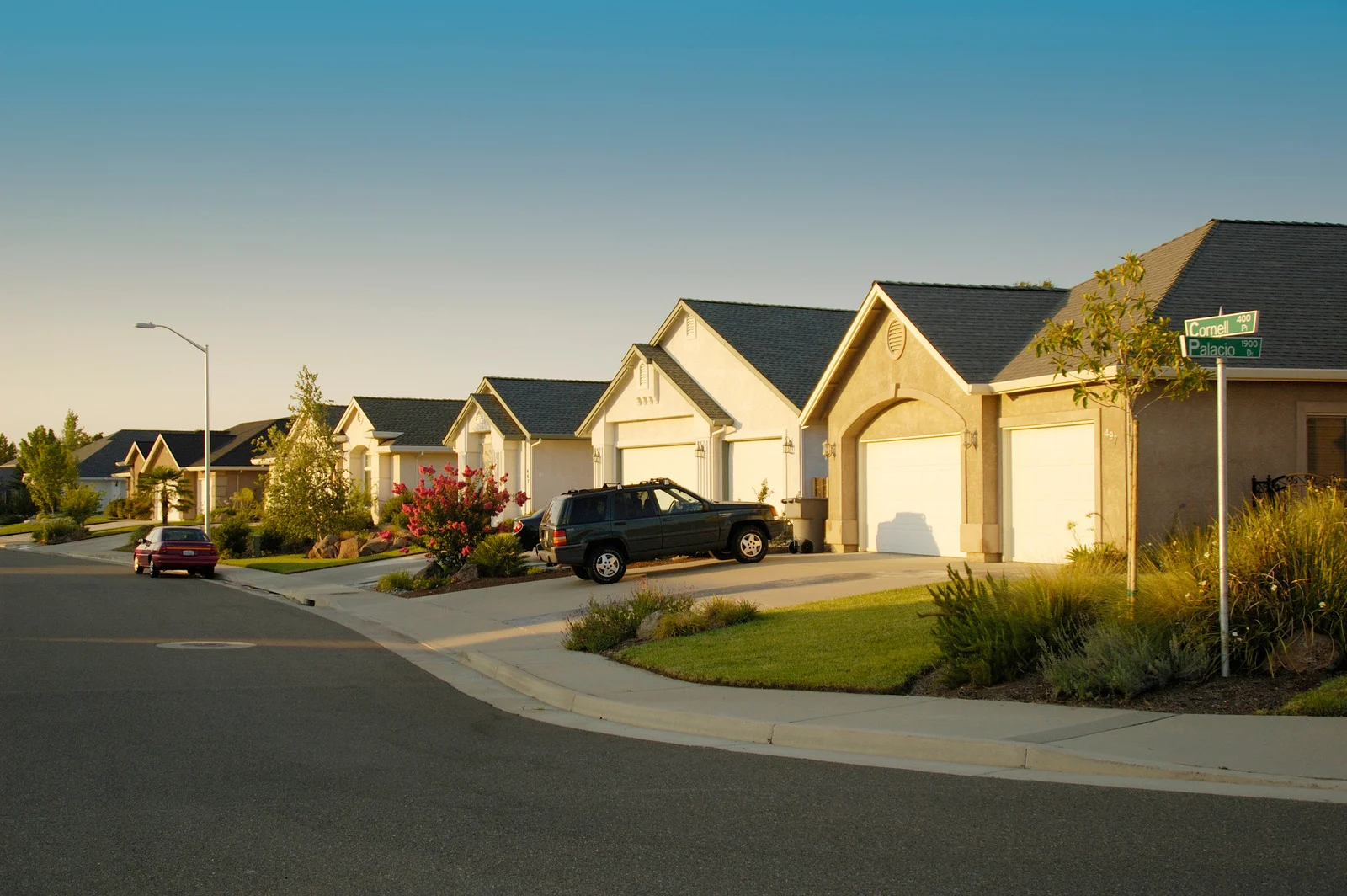 Suburban street with houses and cars.