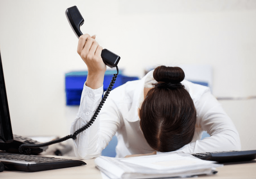 Woman in office overwhelmed with phone call.