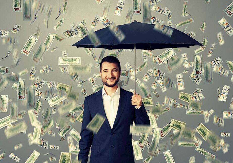 Man holding umbrella under money rain.